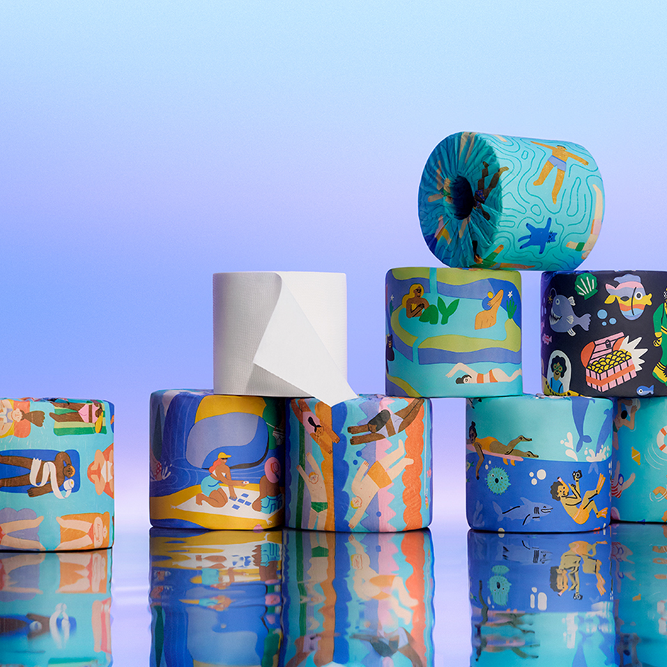 A group of Who Gives A Crap Splash Edition bamboo toilet rolls arranged together, displaying a variety of illustrated water-themed wrappers featuring swimmers, rivers and ocean scenes
