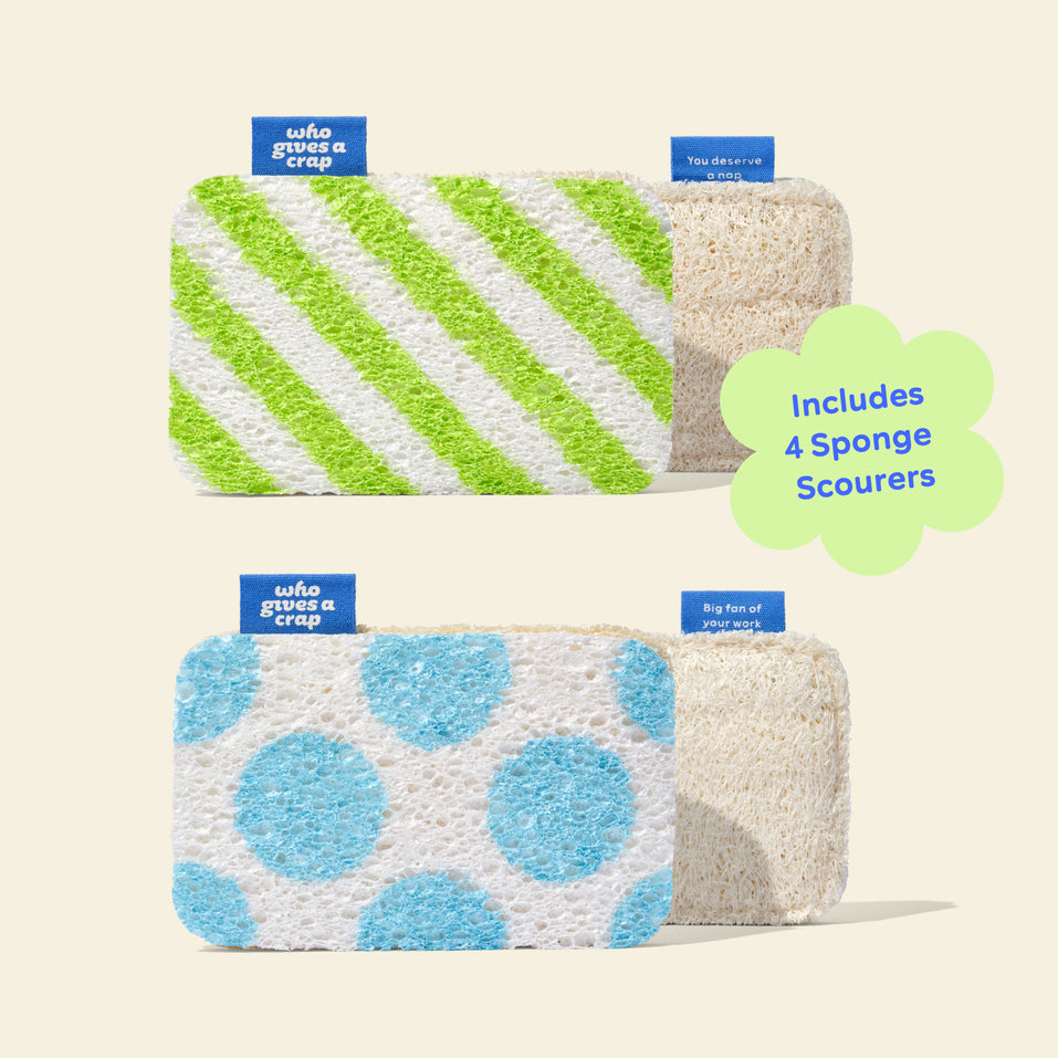 Two pairs of Who Gives A Crap Sponge Scourers showing both designs — green stripe and blue polka dot — each paired with the natural loofah scrubbing side, with a callout noting the pack includes 4 Sponge Scourers