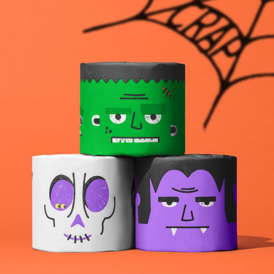 Spooky Edition toilet paper rolls featuring Frankenstein, Dracula and skull designs stacked against orange background.
