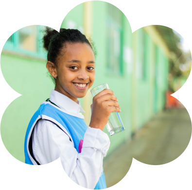 Young school girl holding a clean glass of water.