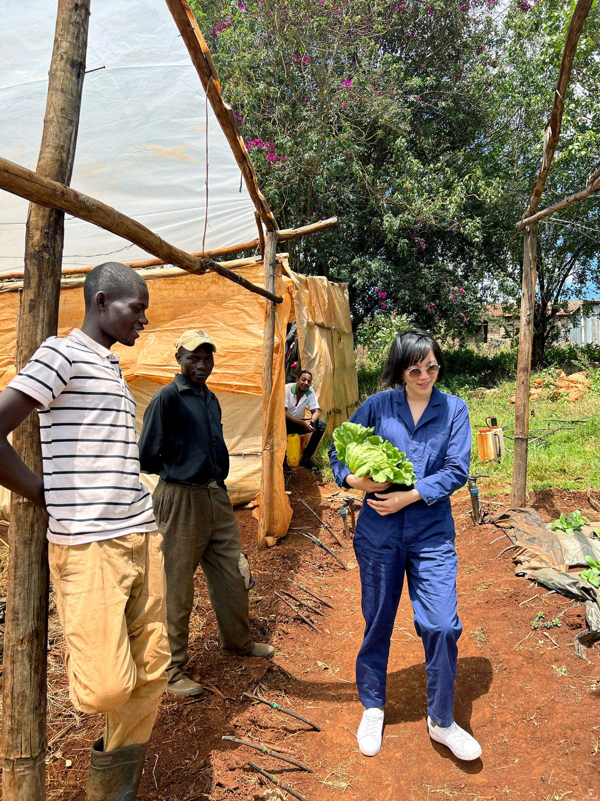Who Gives a Crap employee carries lettuce and stands next to two men outside