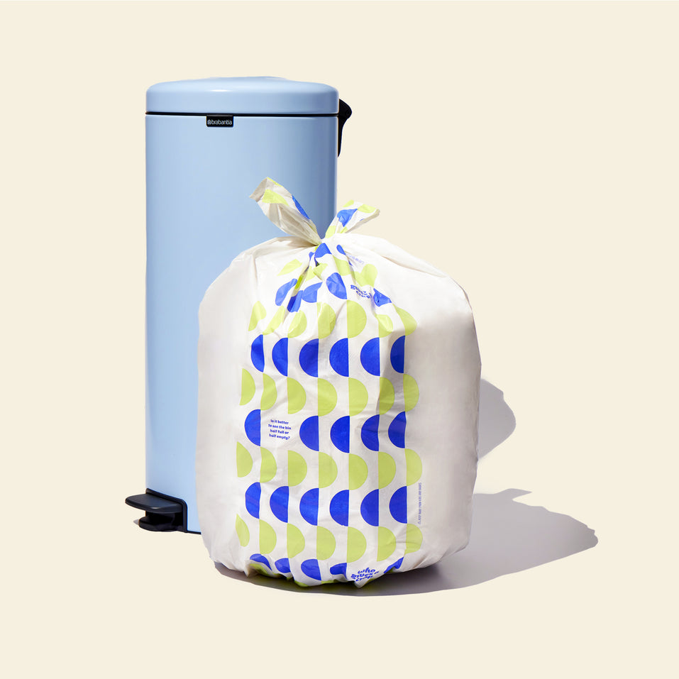 Who Gives a Crap large recycled garbage bag sits full next to kitchen bin