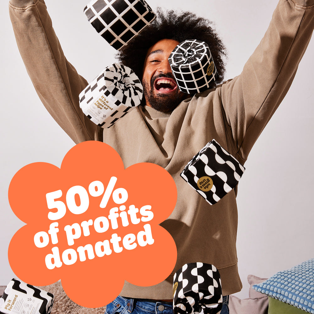 Smiling man throws up rolls of Who Gives a Crap bamboo toilet paper with 50% of profits donated badge